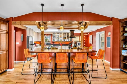 Stylish Kitchen Bar & Gathering Space - This spacious kitchen bar offers seating for six, perfect for casual meals or entertaining. Warm wood beams, elegant lighting, and an open layout create a welcoming atmosphere for friends and family.