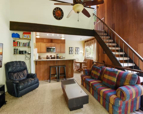 Living room with Smart TV, wood burning fireplace, and balcony access