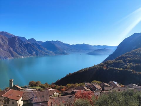 Water, Sky, Mountain, Building, Natural Landscape, Highland, Plant, Tree, Lake, House