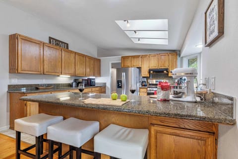 Bar seating in the family room gives guests a perfect place to enjoy happy hour while the chef of the family prepares meals in the light-filled kitchen.