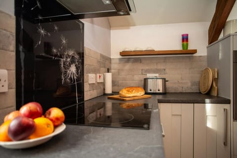 Kitchen with electric hob and extractor hood and feature splashback