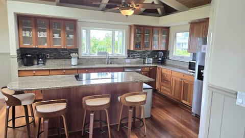 - Granite counters and wood cabinetry highlight full kitchen - Bar stools at island offer space for casual breakfast bites - Large windows frame tropical greenery while you cook here