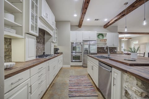 Fully equipped kitchen with stainless steel appliances, rustic beams, and ample counter space—perfect for cooking and gathering.