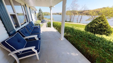 Inviting front porch overlooking Lake Logan with comfortable seating to relax.