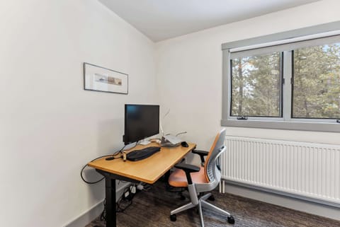 Bedroom 1: Queen bed, main floor, desk with monitor, small window with mountain view