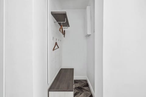 Praktischer Garderobenbereich mit Haken, Ablage, Kleiderbügeln und Sitzbank.