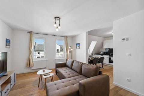 Das offene Wohnkonzept verbindet den hellen Wohnbereich mit einer gemütlichen Couch und TV nahtlos mit der modernen Küche samt Essbereich.