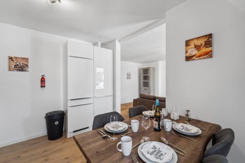 Der Essbereich mit stilvollem Holztisch und moderner Ausstattung verbindet sich harmonisch mit dem offenen Wohnkonzept.