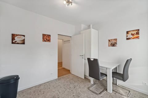 Der kleine Essbereich mit zwei modernen Stühlen und einem weißen Tisch eignet sich ideal für gemütliche Mahlzeiten oder als Arbeitsplatz.