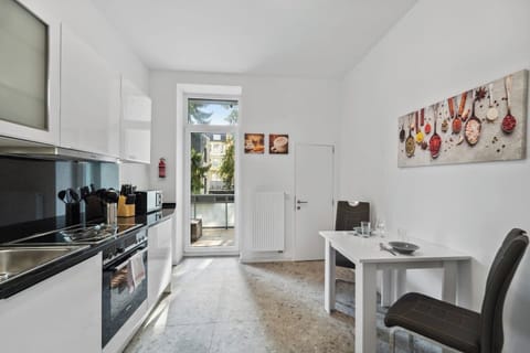 Moderne Küche mit glänzenden Fronten, kompletter Ausstattung und direktem Zugang zum Balkon.