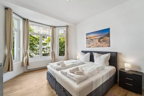 Gemütliches Schlafzimmer mit großem Doppelbett, modernen Möbeln, Fenstern für viel Licht.