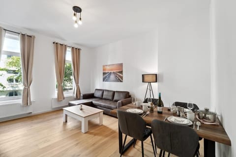 Das gemütliche Wohnzimmer in Wilhelmshaven kombiniert eine komfortable Sofaecke, einen stilvollen Essbereich und große Fenster, die den Raum mit viel Tageslicht durchfluten.