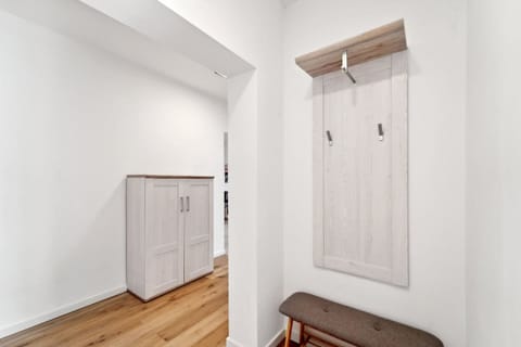 Der einladende Flur in Wilhelmshaven überzeugt mit heller Garderobe, praktischer Sitzbank und modernem Holzfußboden für ein freundliches Ambiente.