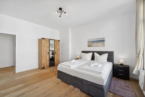 Das geräumige Schlafzimmer in Wilhelmshaven überzeugt mit einem großen Doppelbett, modernem Kleiderschrank im Holzdesign und heller, freundlicher Atmosphäre.