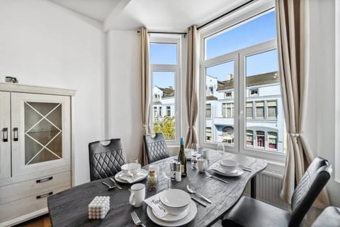 Der stilvolle Essbereich am großen Fenster punktet mit elegant gedecktem Tisch, modernen Lederstühlen und viel Tageslicht für ein gemütliches Ambiente.