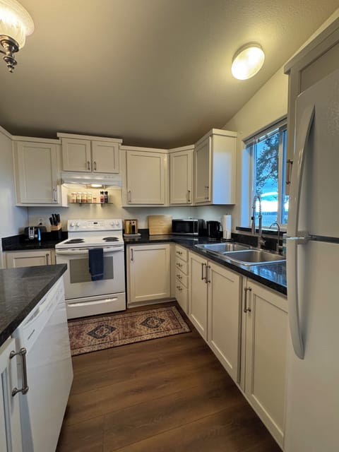Kitchen with stove, oven, dishwasher, blender, toaster, kettle and coffee maker.