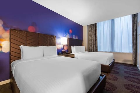 Unwind in crisp linens beside a bright city-facing window.