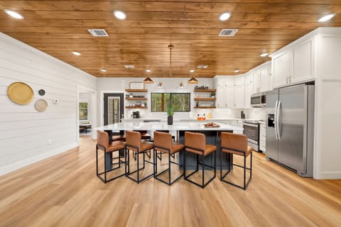 This inviting kitchen features a spacious Quartz countertop, oversized barstools surrounding an oversized island with plenty of room for storage!