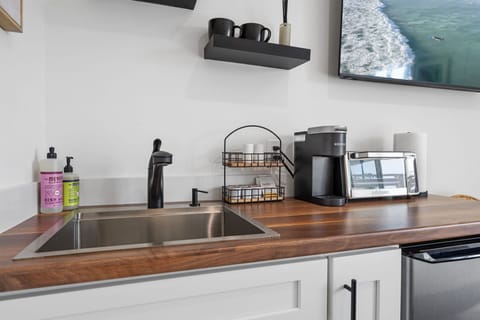 This modern, well equipped kitchenette with a small fridge, microwave, toaster oven/air fryer combo, and Keurig coffee maker -perfect for effortless meals and morning coffee.