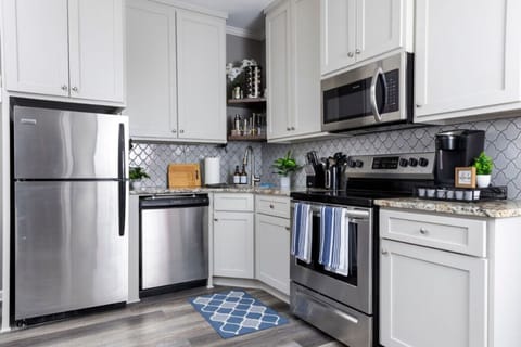 Step into this fully equipped kitchen, where sleek stainless steel appliances shine against a cozy blue rug, perfect for cooking and creating memories!