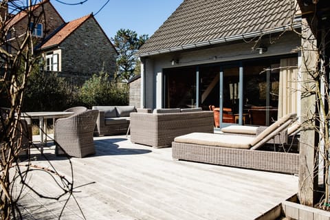 Exterior view of the villa and garden with outdoor seating