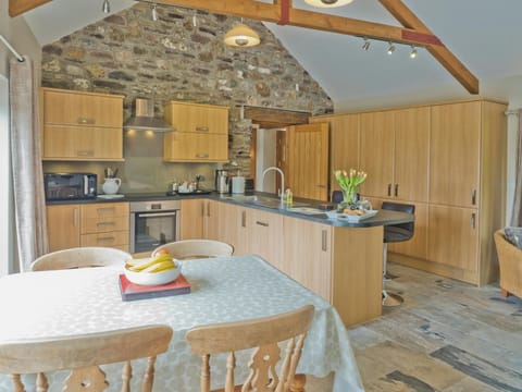 Living area with table and chairs, kitchen and breakfast bar