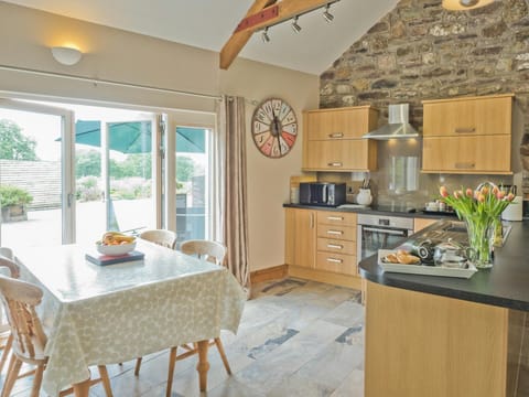 Living area with table and chairs, kitchen and breakfast bar