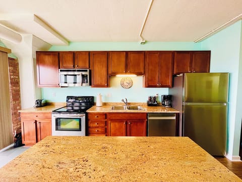 Cook with ease in this modern kitchen featuring rich wood cabinetry, sleek stainless steel appliances, and a large granite island perfect for meal prep or casual dining.