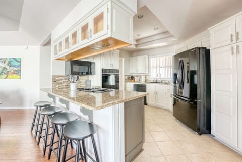 Sleek kitchen with breakfast bar & lots of prep space—enjoy home-cooked meals and morning coffee.