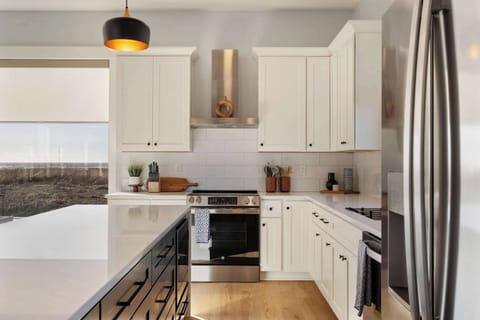 Gas stove, open shelves, and full cookware—set up for real cooking and casual meals.