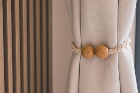 Stylishly tied curtains in warm amber tones add elegance and a cozy glow to the space.