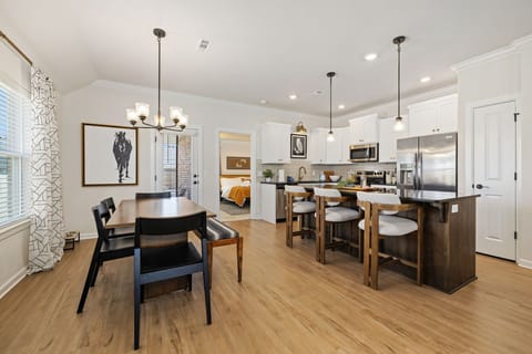 A dining table with 4 chairs and a bench, comfortably seating up to 6. The kitchen island features 3 barstools, providing additional seating for casual meals or conversations.