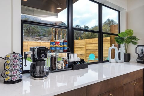 Fully stocked coffee bar with k-cups, ground coffee, hot cocoa, creamer, and flavorings.