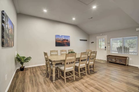 The spacious dining area features a rustic wooden table with seating for eight, perfect for shared meals and lively conversation. Gather, dine, and enjoy the warmth of this inviting space.