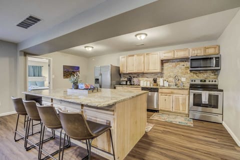 The fully equipped kitchen features stainless steel appliances, a spacious island with bar seating, and a stylish stone backsplash. Perfect for preparing delicious meals while staying connected with family and friends.