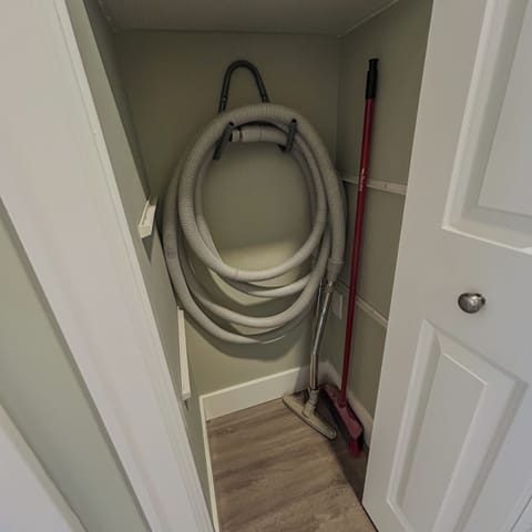 Hall closet stores all of the necessary cleaning supplies and central vacuum.