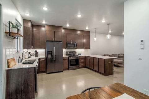 View from the dining space showcasing the expansive kitchen layout, sleek countertops, and contemporary finishes for a stylish stay.