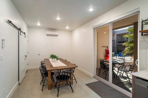 Spacious dining area with seating for eight, conveniently located near the back patio for seamless indoor-outdoor dining. The barn-door style pantry contains pickleballs and paddles, pool towels, and other various items for your enjoyment.