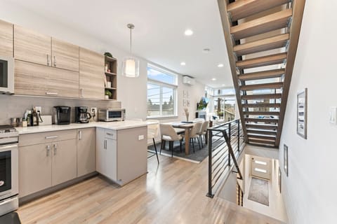 Modern kitchen with dining area and open staircase.