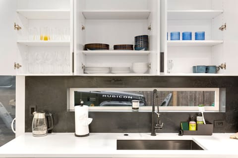 Dishes and glassware are easy to find. Clean, well-stocked cabinets above the sink.