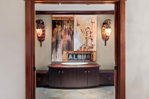 A beautifully designed entry to the primary suite, accented with Hawaiian artwork and custom wood finishes.