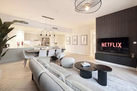 Cozy living room with a 65″ smart TV and Netflix. The open layout connects smoothly to the kitchen, creating a comfortable space to relax after a day in the city.