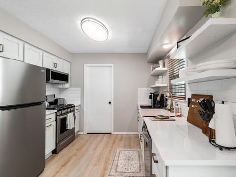 Whip up meals in style in this sleek, modern kitchen! 🍽️✨ Stainless steel appliances, open shelving, and a coffee station make cooking feel effortless and inviting. ☕🔪