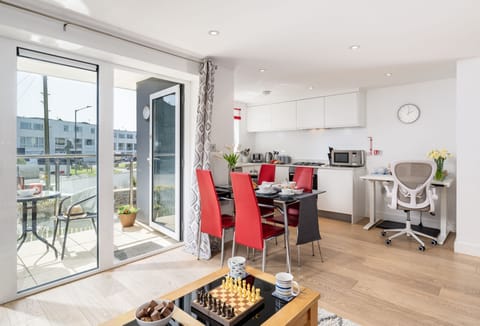1 Ocean Gate, Newquay: This stylish apartment boasts an open-plan living space where natural light pours in through the south-facing balcony, creating a warm and welcoming atmosphere