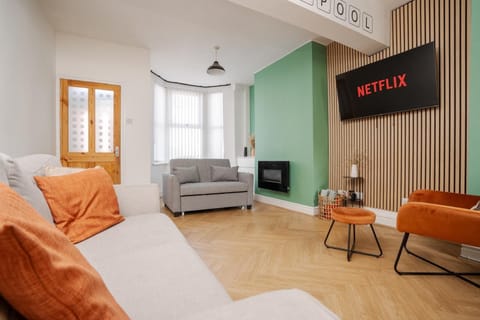 The comfortable living space includes a Smart TV with Netflix, a sofa bed for additional sleeping space, and a chair with an ottoman set—perfect for relaxing after a long day.