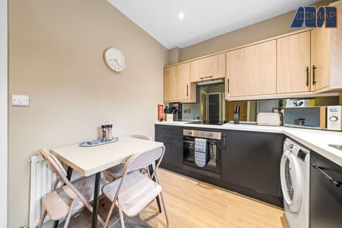 A beautifully designed kitchen with a modern touch! Featuring sleek black and wood cabinetry, built-in appliances, and a cosy dining area—perfect for cooking and enjoying meals in style.
