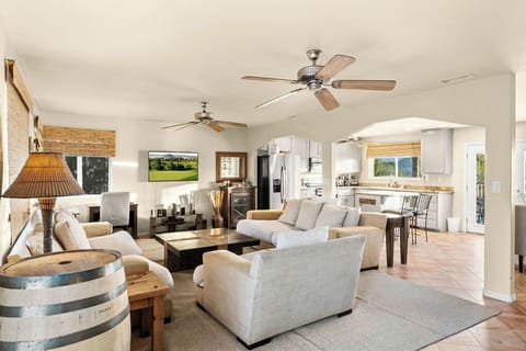 Open living area flows seamlessly into the kitchen and dining space, with an additional pub table and four bar-height stools for extra seating and casual gatherings.