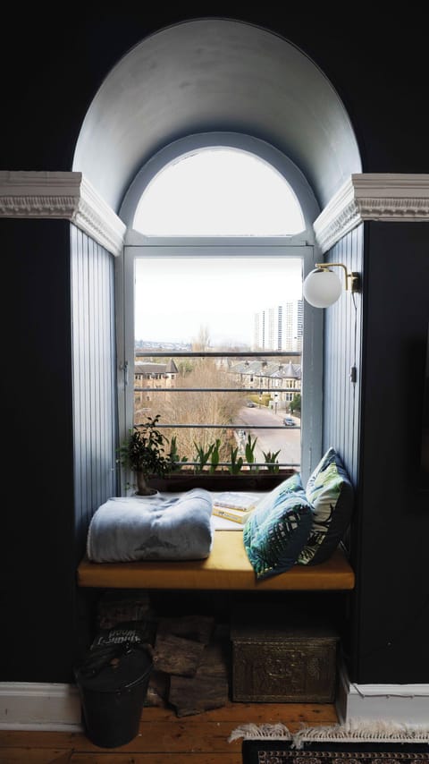 Reading nook in one of 3 arched windows and infront of the fireplace
