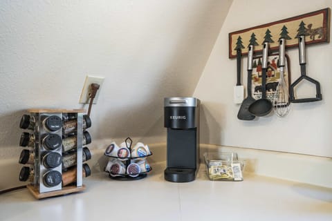 Enjoy your morning brew with a fully stocked coffee station, complete with a Keurig, a selection of pods, and essential cooking tools at your fingertips.








