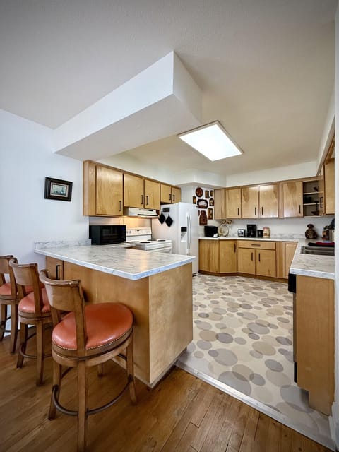 Kitchen with passthrough to the living room and barstools for extra seating